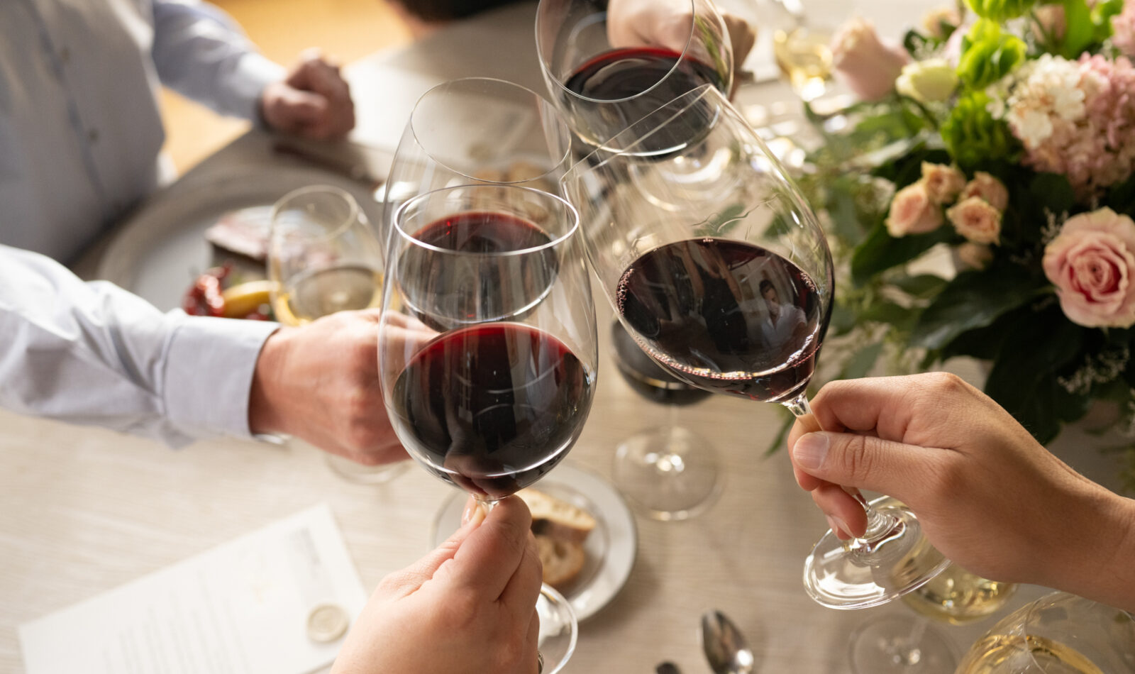 cabernet glasses toasting around a formal dinner table