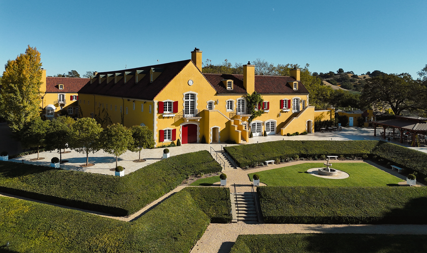 drone shot of jordan winery chateau with yellow walls and gardens